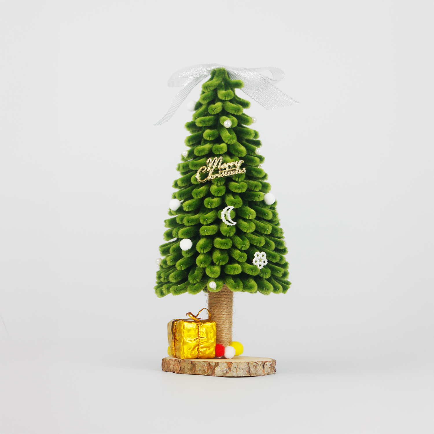 Green pipe cleaner Christmas tree with silver ribbon, mini ornaments, pom-poms, and golden gift box on rustic wood base – perfect handmade holiday decor or DIY Christmas gift