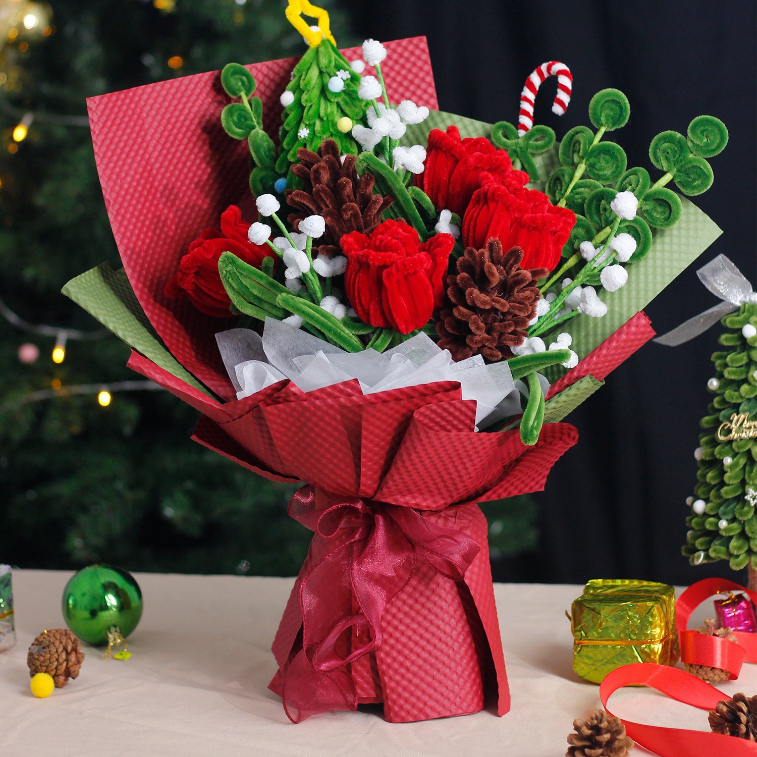 Handmade bouquet with green and white pipe cleaner flowers, wrapped in rich dark green paper and ribbon. Elegant evergreen design perfect for Christmas and winter décor.