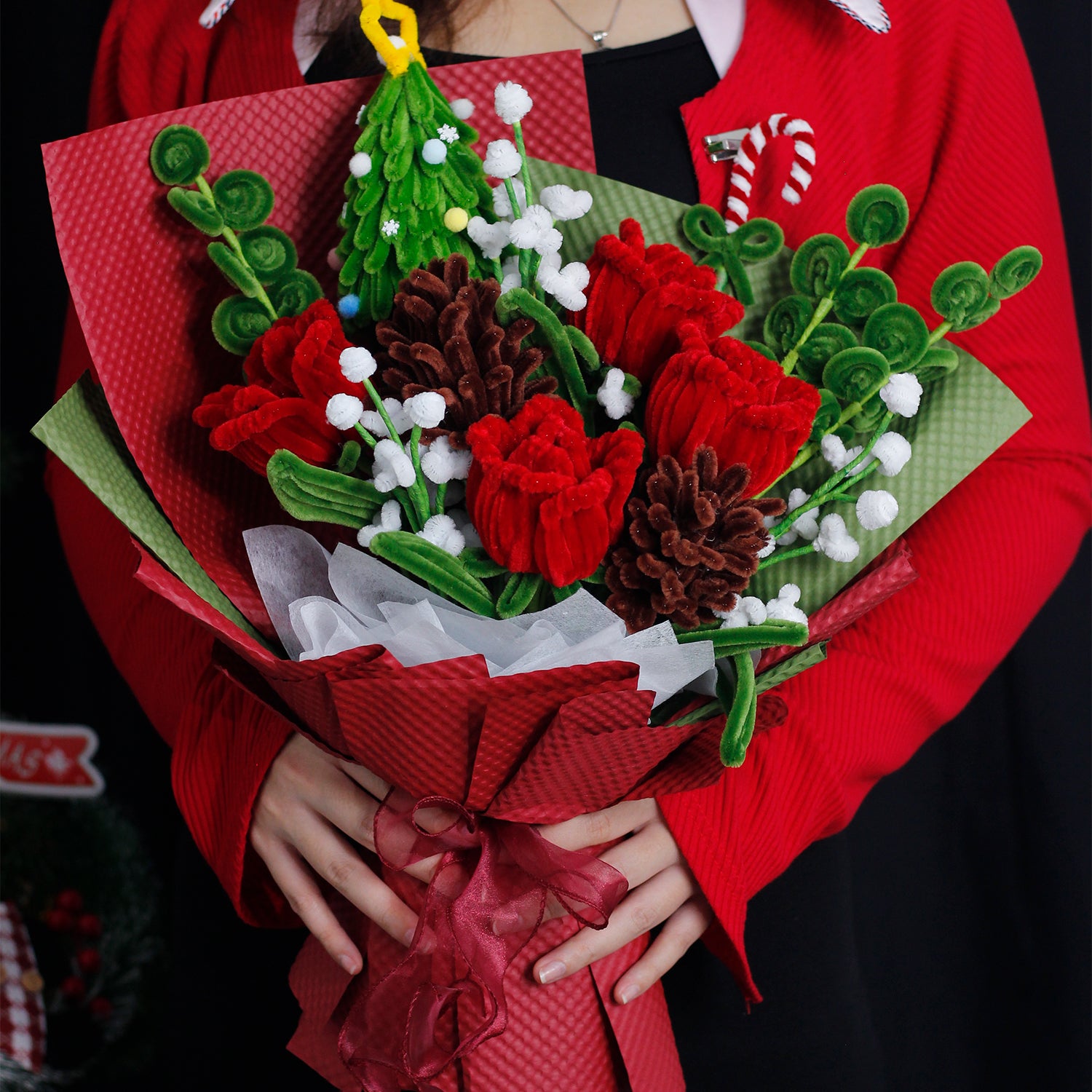 Handmade bouquet with green and white pipe cleaner flowers, wrapped in rich dark green paper and ribbon. Elegant evergreen design perfect for Christmas and winter décor.