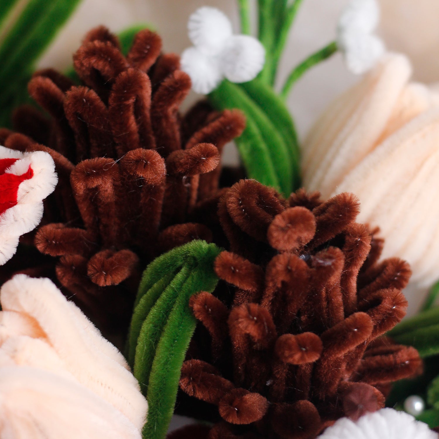 Handmade bouquet of white and blue pipe cleaner flowers wrapped in soft blue and white paper with ribbon. Features lifelike lilies and daisies. A winter-inspired, everlasting floral gift.