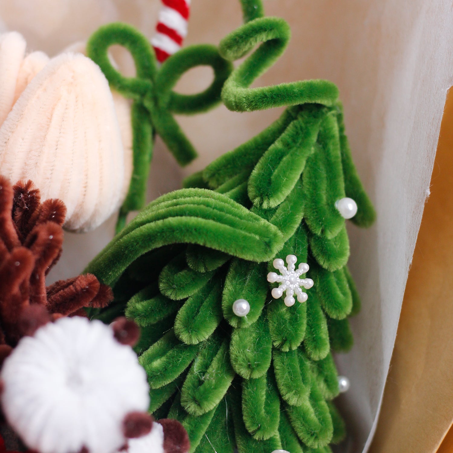 Handmade bouquet of white and blue pipe cleaner flowers wrapped in soft blue and white paper with ribbon. Features lifelike lilies and daisies. A winter-inspired, everlasting floral gift.