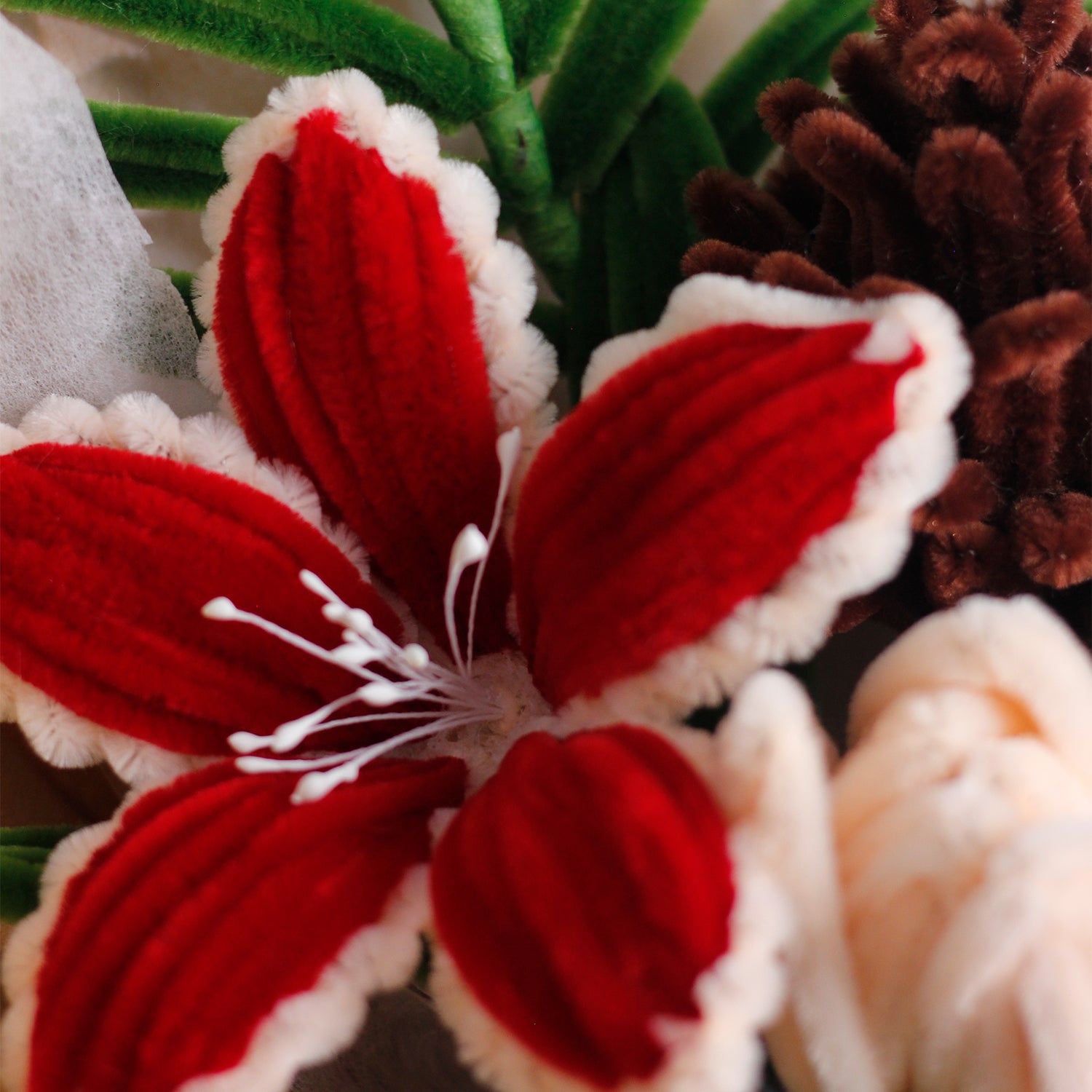 Handmade bouquet of white and blue pipe cleaner flowers wrapped in soft blue and white paper with ribbon. Features lifelike lilies and daisies. A winter-inspired, everlasting floral gift.