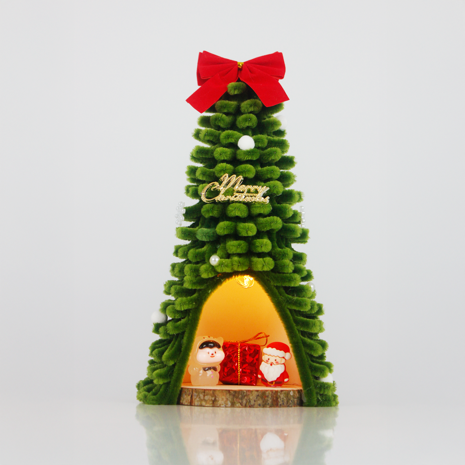 Green fuzzy wire Christmas tree featuring Santa Claus and pig figurine inside, topped with red bow – unique and charming holiday decor